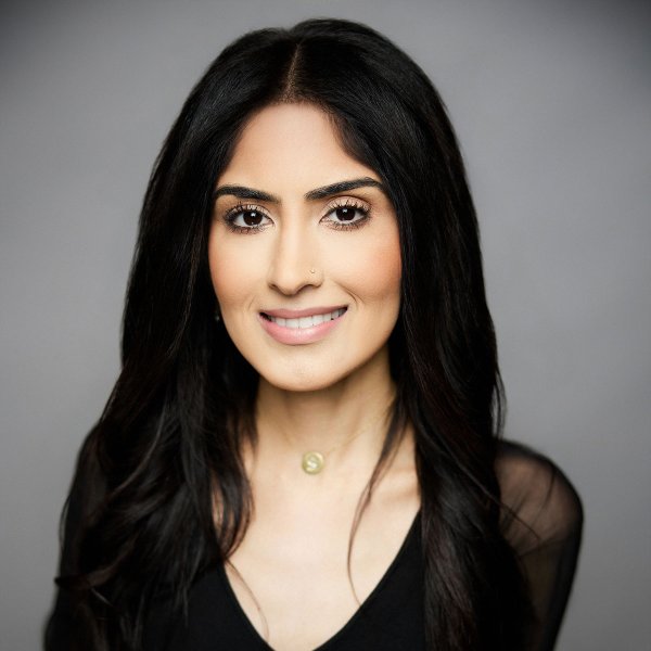 Young Woman Smiling By Green Wall
